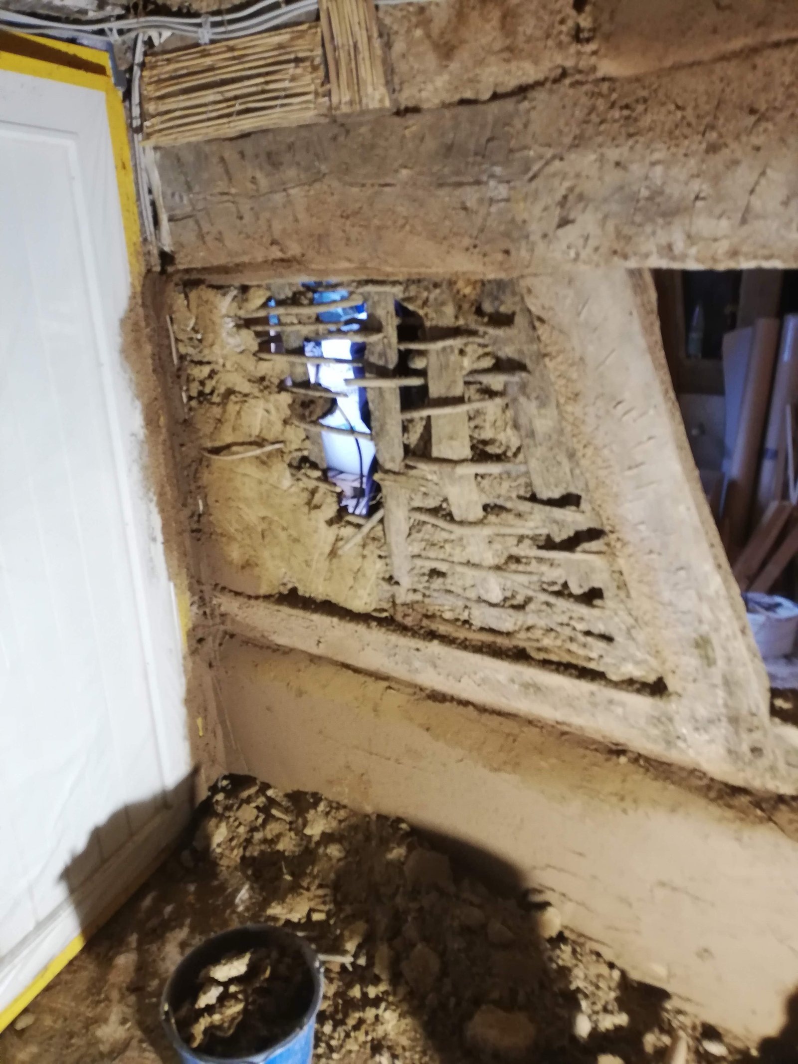 Fachwerkwand teilweise abgebrochen: Holzbalken und Ausfachung aus Lehmziegeln