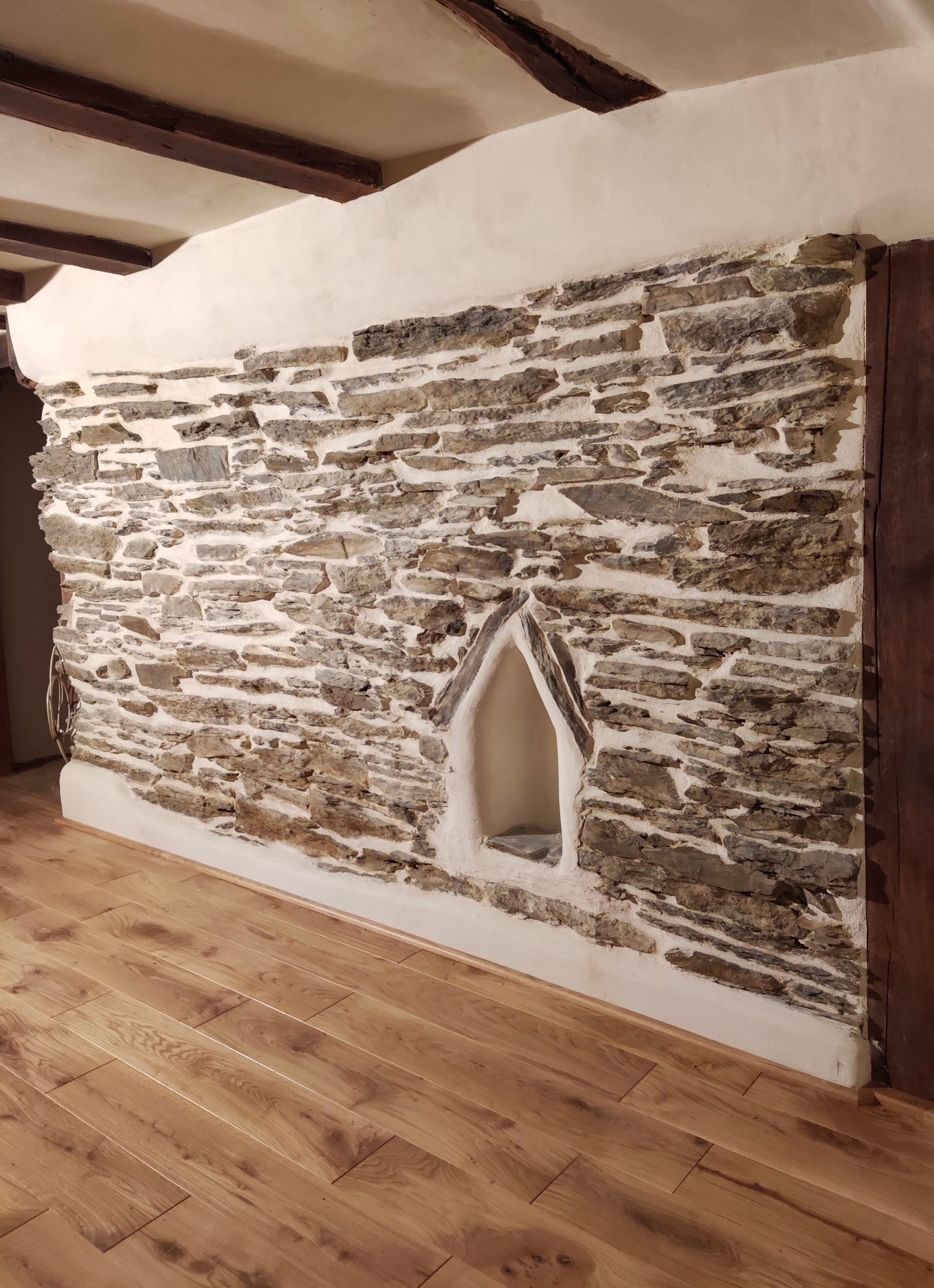 Saniertes Fachwerkhaus: freigelegte Bruchsteinwand mit Bogennische als Designelement