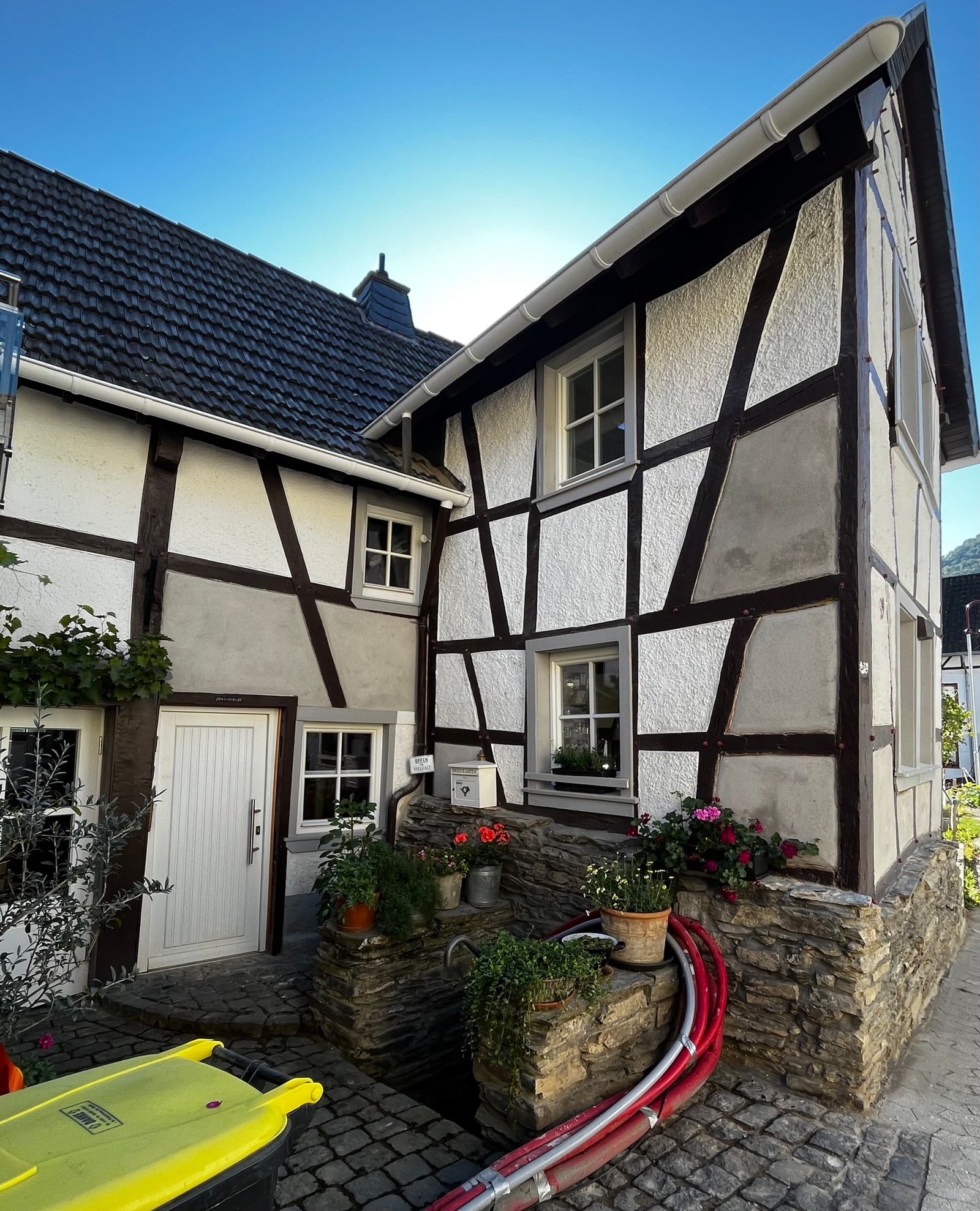 Saniertes Fachwerkhaus Ahrtal Gesamtansicht: helle Fassade, kleiner Eingang, Bepflanzung