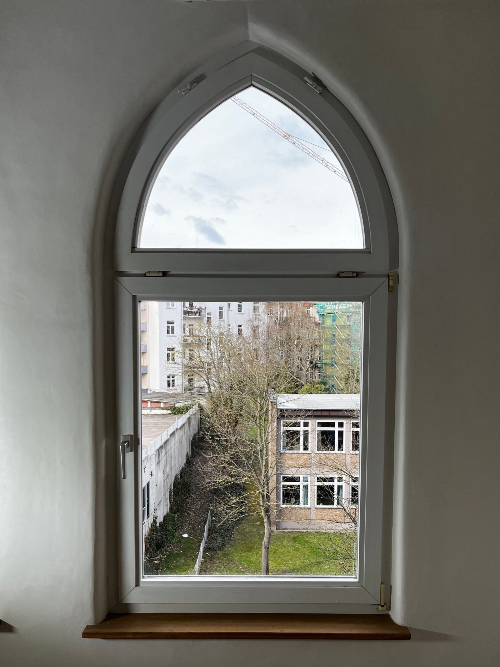 Neugotisches Spitzbogenfenster nach Restaurierung, weißer Kalkputzleibung, Innenansicht