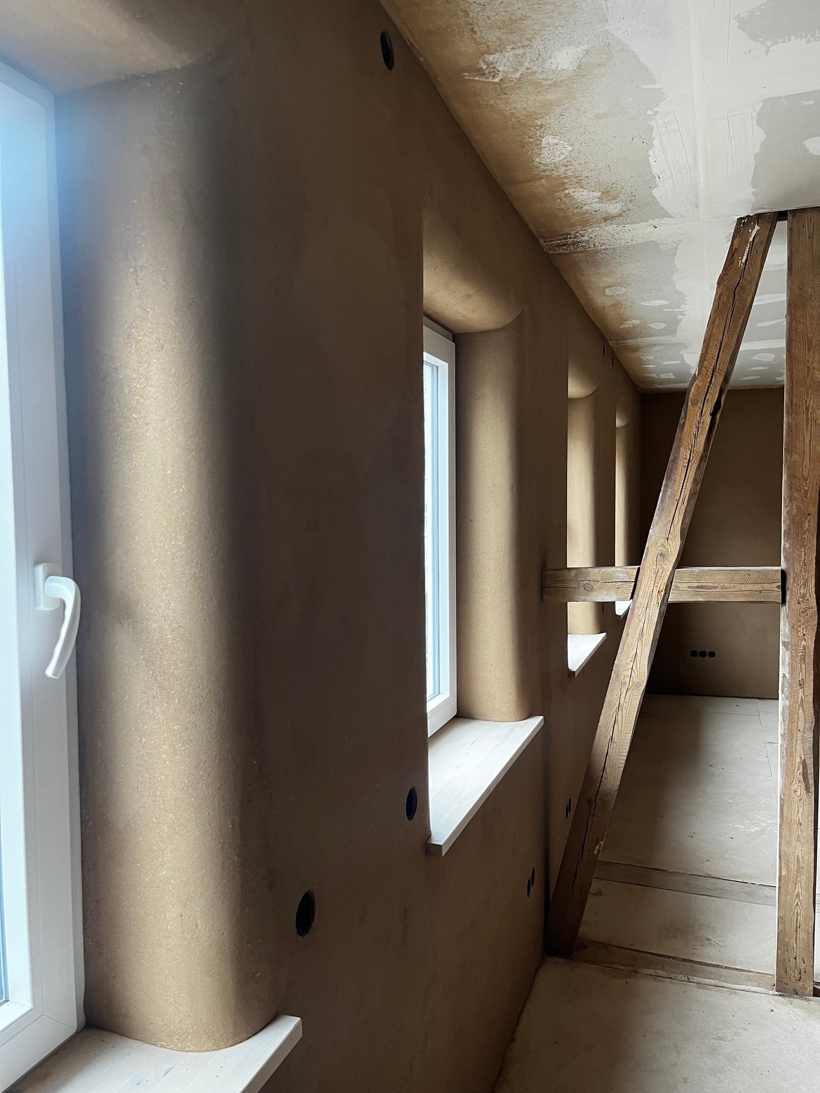 Lehmputzdecke mit eingelassenem Fenster und Holzbalken, Detailansicht Treppenauge