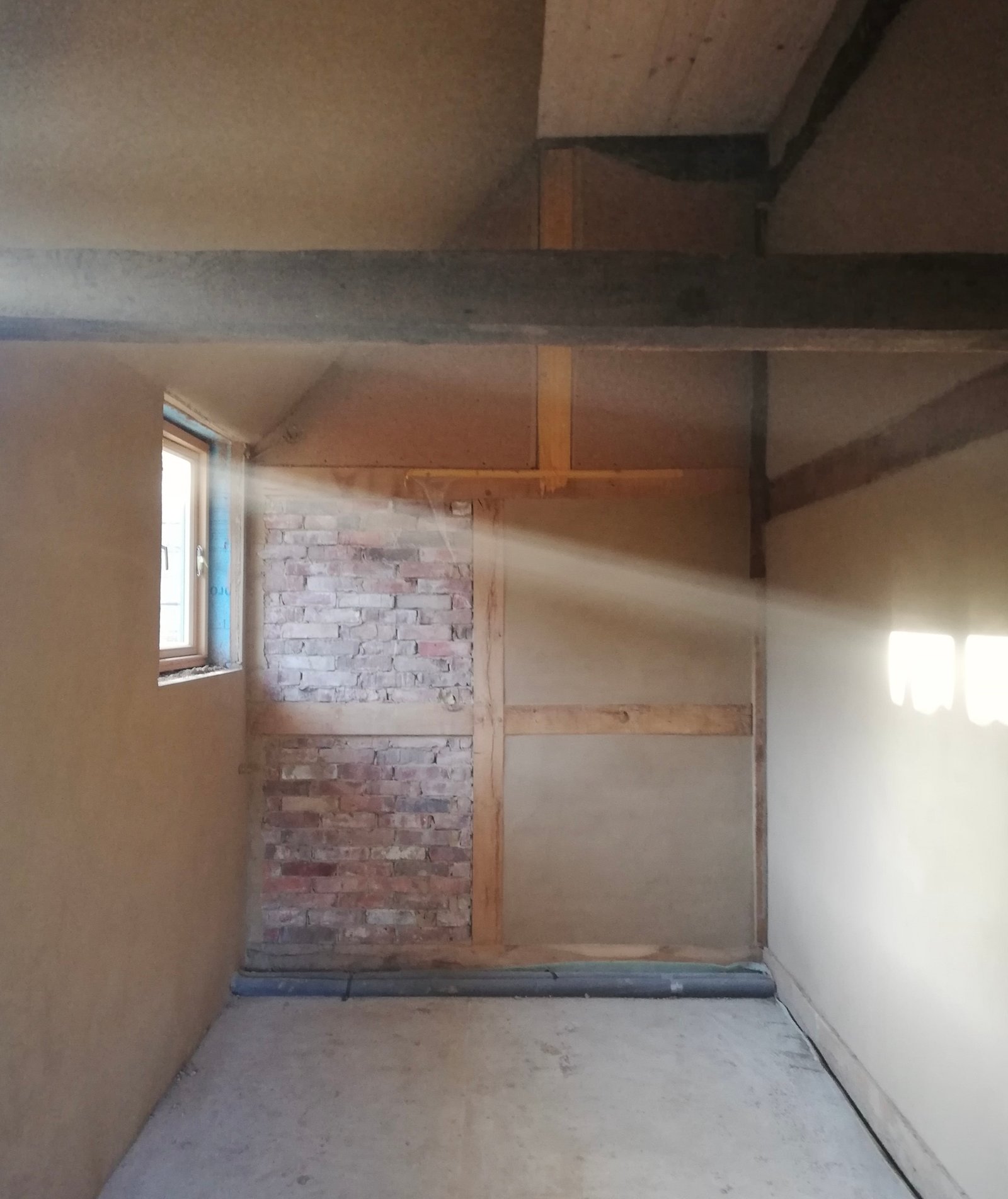 Lehmputz-Innenraum Fachwerkhaus Niedersachsen: warme Wandflächen, Ziegelausfachung sichtbar