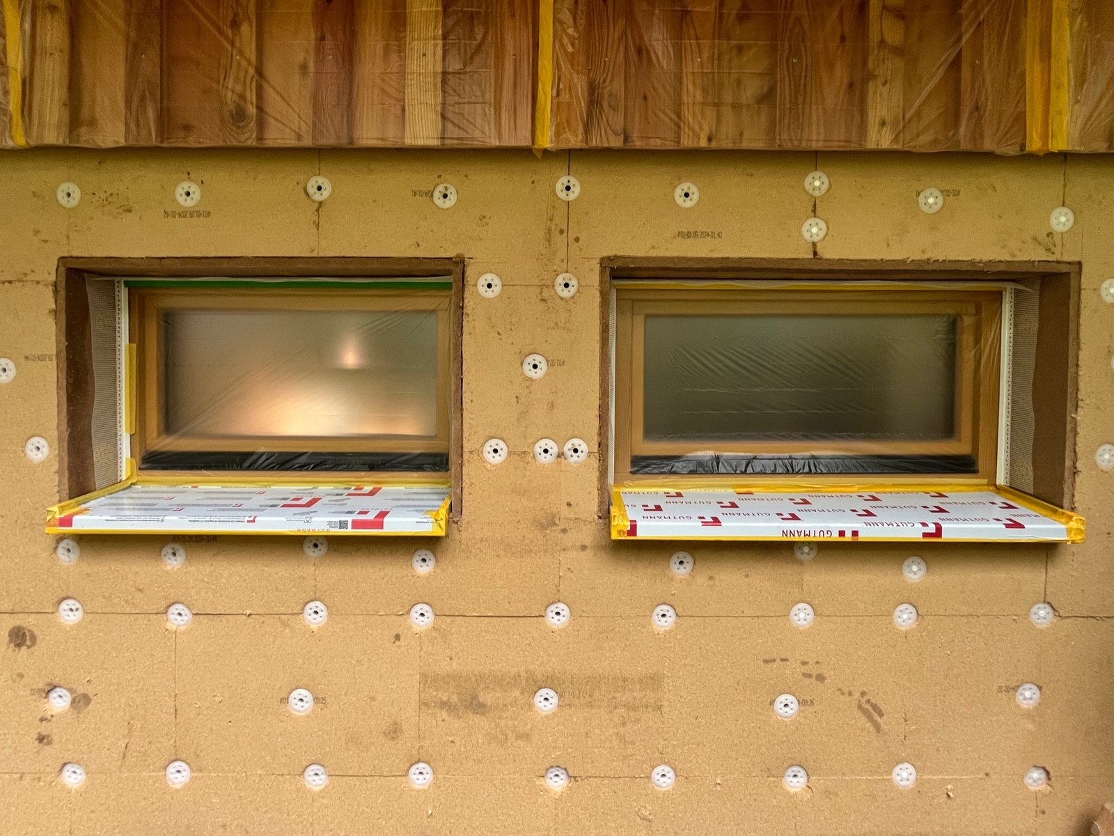 Kalkputz auf Holzfaserdämmung: Unterputzschicht aufgetragen, Kellerfenster integriert