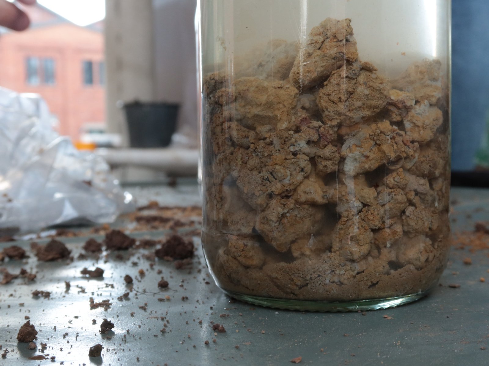 Lehmprobenanalyse: Glasflasche mit Lehm-Wasser-Gemisch, Sediment sichtbar