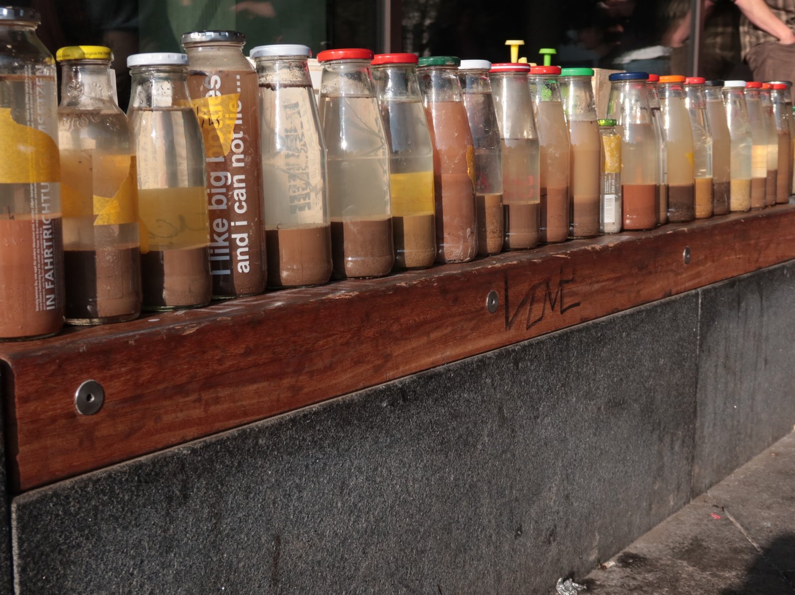 Lehm-Workshop öffentlich: Lehmprobenflaschen auf Regal in der Stadt