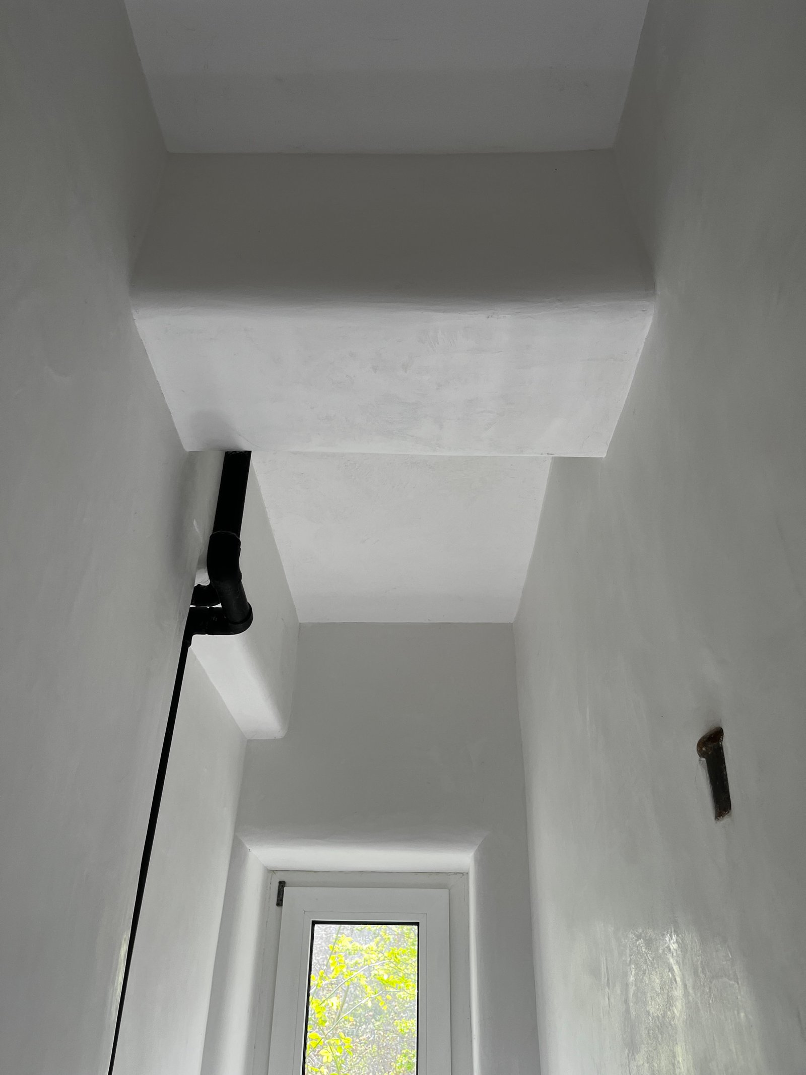 Fertig sanierter Raum nach Schimmelbehandlung: weißer Kalkputz, Kaminbereich