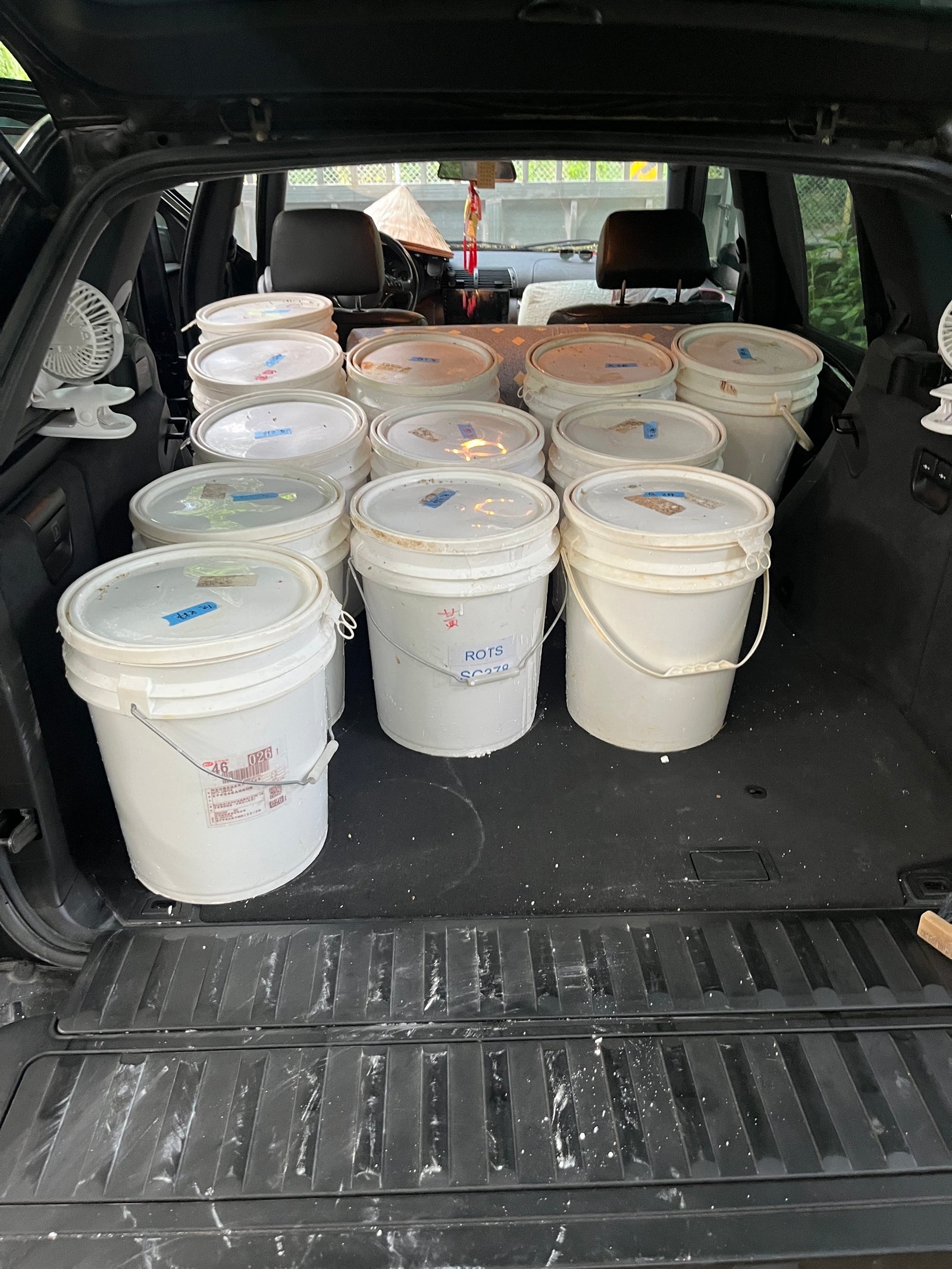 Lehmputzmaterial-Transport: zehn Eimer im Kofferraum eines Fahrzeugs