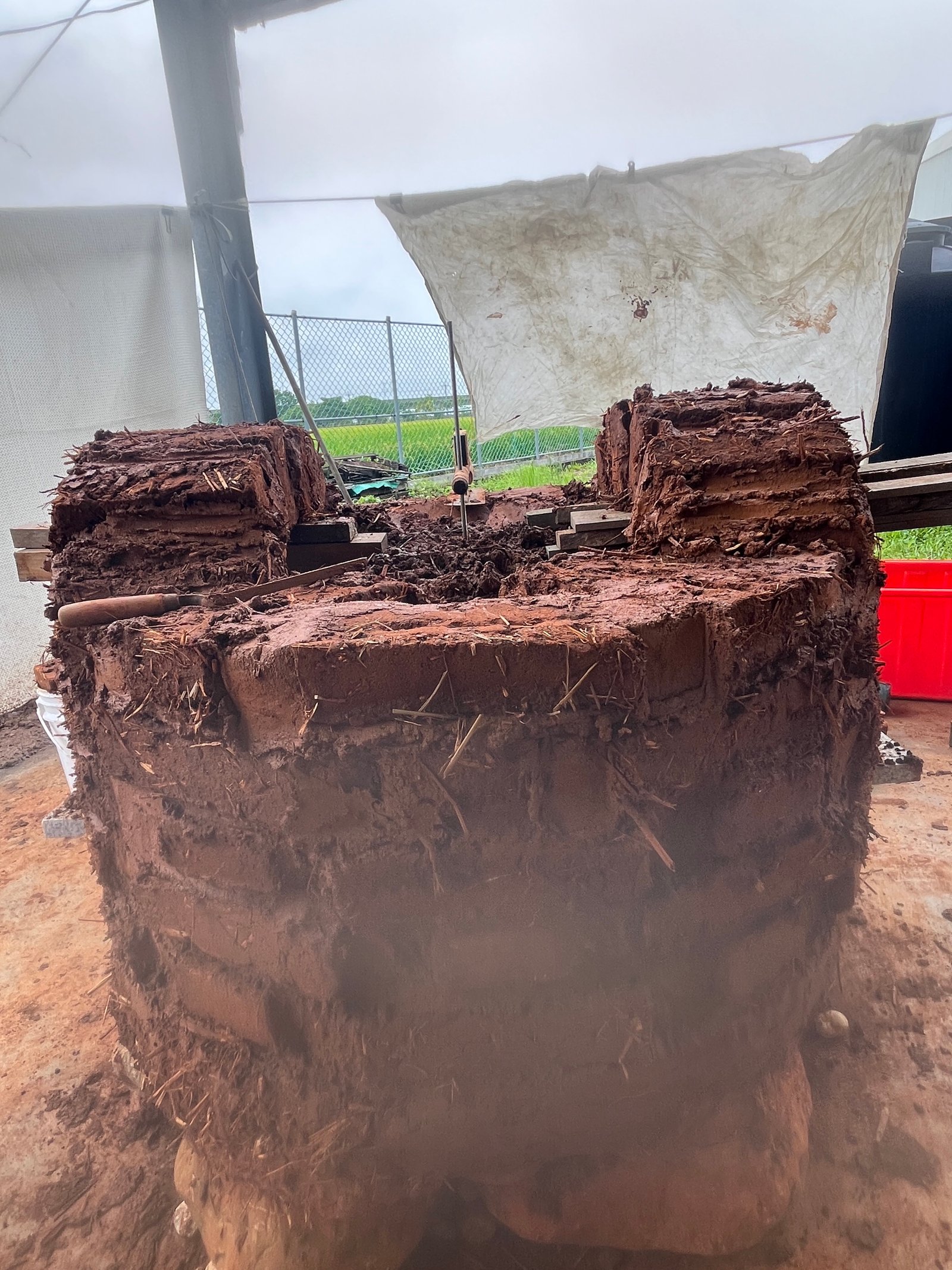 Runder Lehmbackstein-Ofen fertig geformt: Außenputz aus Lehm und Stroh