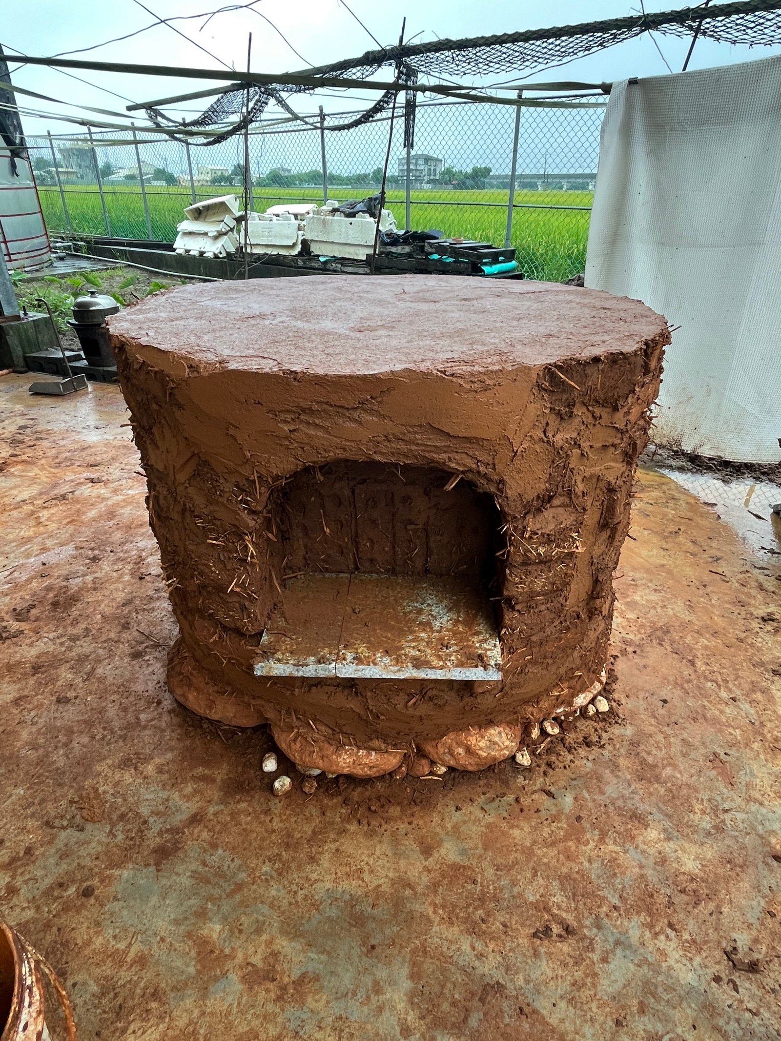 Lehmbackstein-Ofen fertig: runde Silhouette, Lehmputz außen, Taiwan-Hof