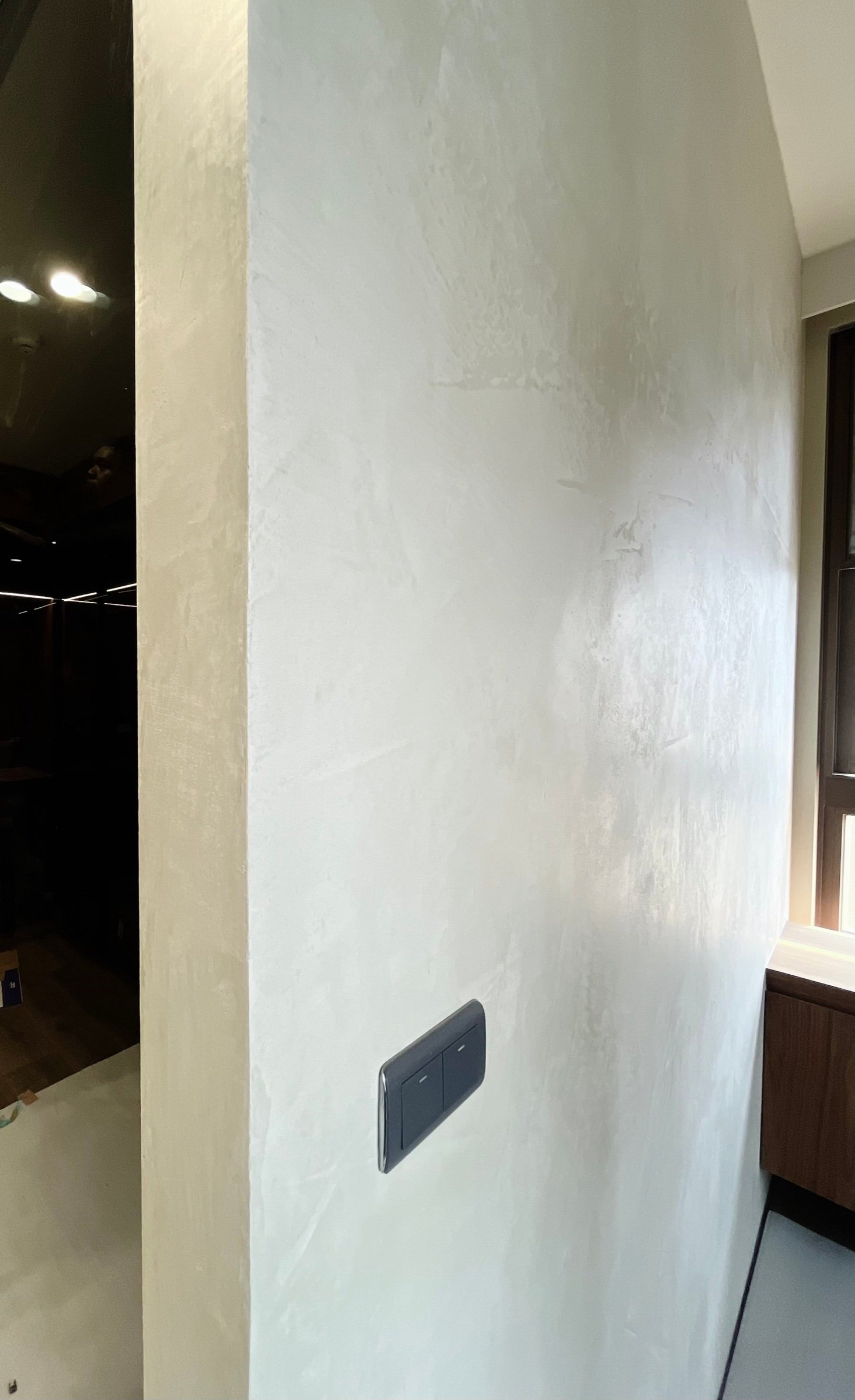 Kalkputzwand-Ecke mit Lichtschalter: heller Mineralputz, moderner Innenraum Taiwan